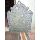 A small vintage cast iron fire back of stepped arched form with raised relief stork and trailing