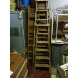 Four vintage wooden 'A' framed folding step ladders of varying height
