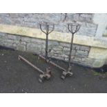 A pair of wrought iron andirons with basket finials and scrolled supports