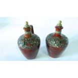 An interesting pair of Doulton Lambeth flagons and stoppers with mottled brown glaze and relief