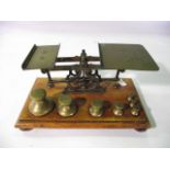 A late 19th/early 20th century assembly of postal scales, principally in brass raised on a timber