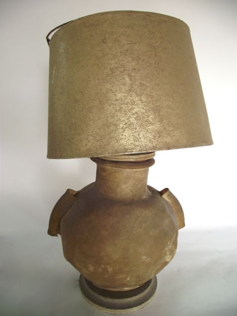 An unusual desk lamp crafted from the bladder of a camel, raised on a circular timber base, 31 cm