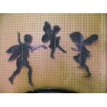 A trio of unusual ironwork silhouettes depicting scampering fairies, all with blackened finish,