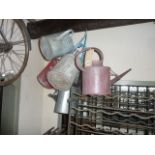 A collection of vintage and later galvanised watering cans of varying capacity