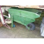 A vintage traditional elm wheelbarrow with removable extension and all over weathered green