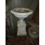 A Victorian cast iron garden urn, the squat circular fluted bowl with egg and dart rim raised on a