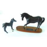 A Beswick matt glazed group of Black Beauty and foal raised on an oval wooden base