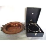 A substantial antique copper charger with shaped rim and extensive applied looping brass handles