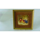 A ceramic plaque in the Royal Worcester manner with painted decoration of peaches and grapes in a