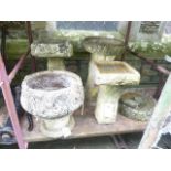 Four weathered bird baths of varying design together with a further weathered cast composition stone