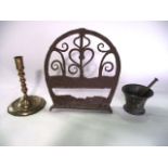 An antique ironwork fireside bracket with scrolling detail, 33 cm tall (when closed) together with