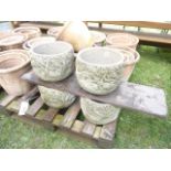 A set of four small weathered cast composition stone garden planters of circular form with bird,