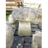 A small weathered cast composition stone staddle stone with domed cap together with a further cast