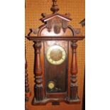 A late 19th century continental wall clock in a walnut case with split spindle mouldings and