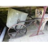 A vintage garden water barrow with iron work frame and spoke wheels