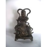 An antique metalwork study of a seated Chinese deity, the figure depicted in a warriors livery, a