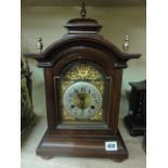 An Edwardian walnut bracket clock in the Georgian style with broken arched dial and applied