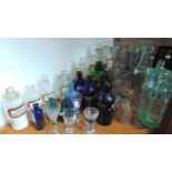 An interesting selection of glassware to include several antique clear glass chemist bottles with