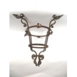 An antique iron work ceiling light/lantern cradle loosely in the Art & Crafts manner with