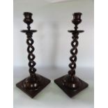 A good quality pair of antique mahogany candlesticks of open twisted form raised on squared bases