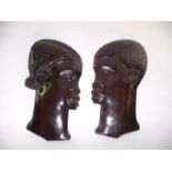 A carved hardwood African figure of a woman, together with two carved African profile face
