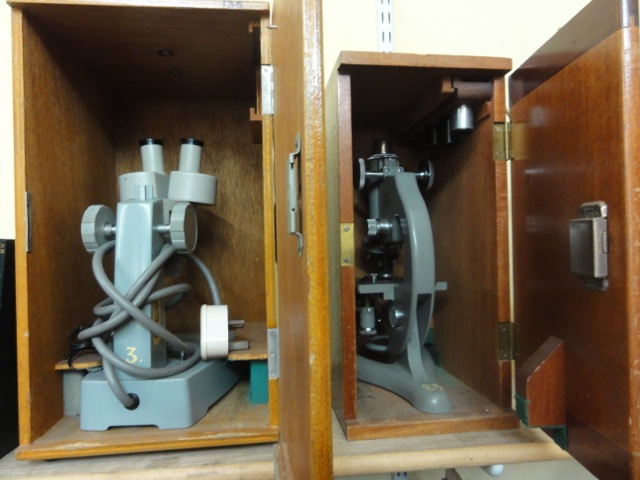 A vintage timber cased electronic binocular microscope together with a further timber cased