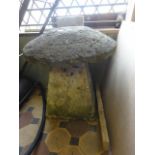 A weathered natural stone staddle stone and domed cap