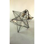 A clear glass ceiling light fitting of star form with brass mounts