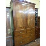 A Regency mahogany hanging cupboard, the lower section enclosed by two long and two short drawers,