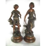 A pair of French spelter figures, one depicting a young boy in shorts clutching a stick and water