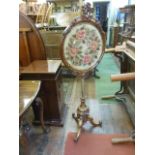 A Victorian walnut pole screen, the circular panel incorporating a drawn woolwork frieze of roses