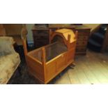 An Old English style oak cradle with canopy set within a pegged and panelled framework