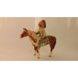 A Beswick equestrian figure of a native American warrior with feathered head dress seated on a brown