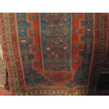 An old Eastern wool rug, the central blue field decorated with symmetrical medallions set within a