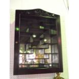 A hardwood wall hanging collectors/display cabinet, the hinged glazed panelled front set beneath a