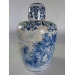 An early 19th century continental tin glazed earthenware jar and cover with blue and white painted