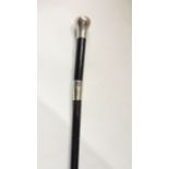 An ebonised walking cane with applied chased silver knop and collar, hallmarked London 1912/13