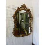A shield shaped wall mirror, the moulded gilt frame with floral detail, 92cm x 60cm approximately