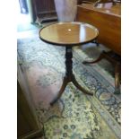 A Georgian mahogany occasional table, the circular dished top raised on a turned pillar and swept