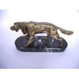 A cast metal study of a standing spaniel, with all-over gilded finish raised on a rounded