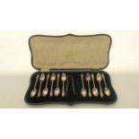 A cased set of eleven Edwardian silver coffee spoons and a pair of sugar tongs, Josiah Williams &