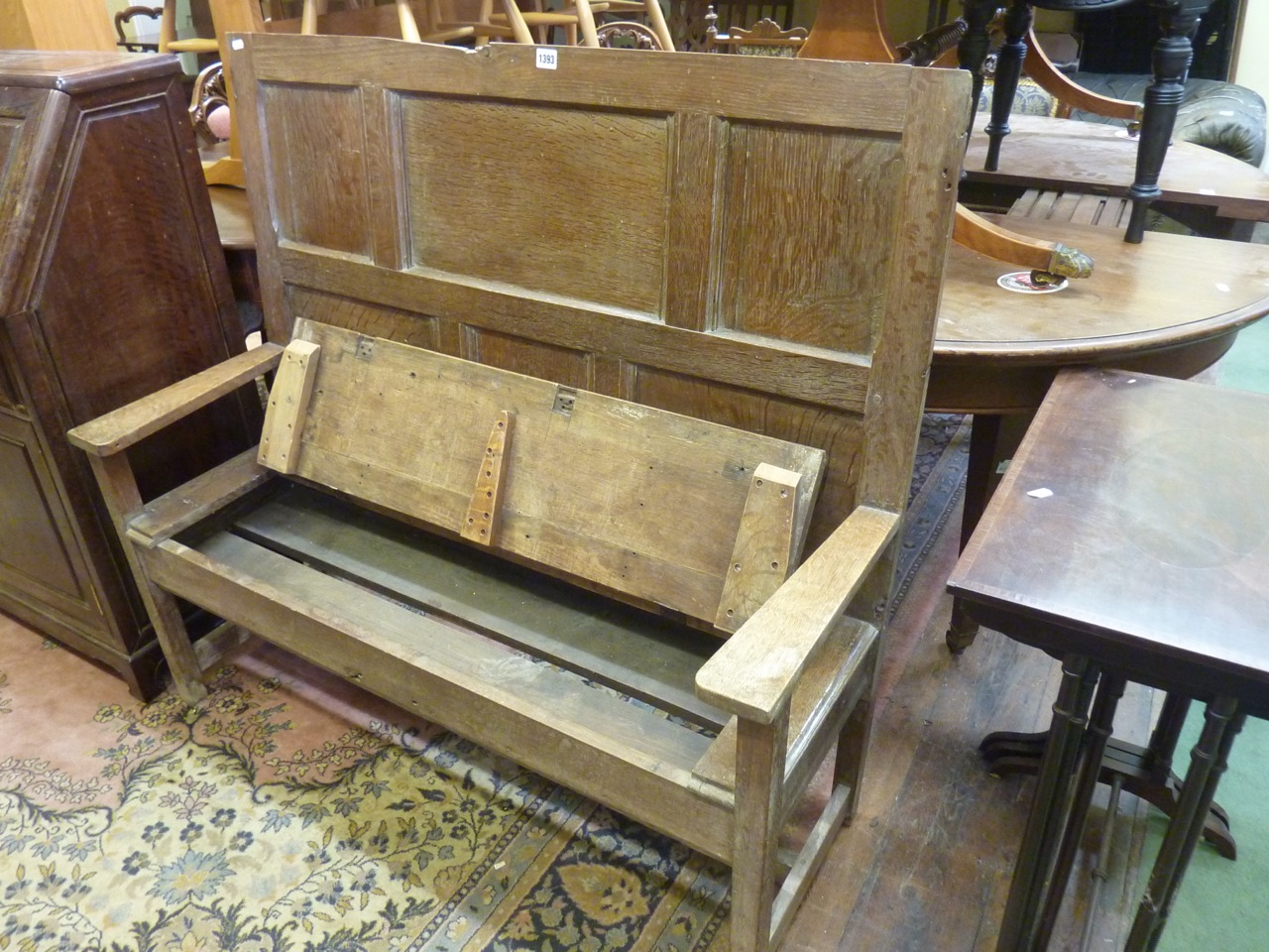 A small Georgian oak settle with panelled back, the shallow box seat with rising lid, raised on - Image 2 of 2