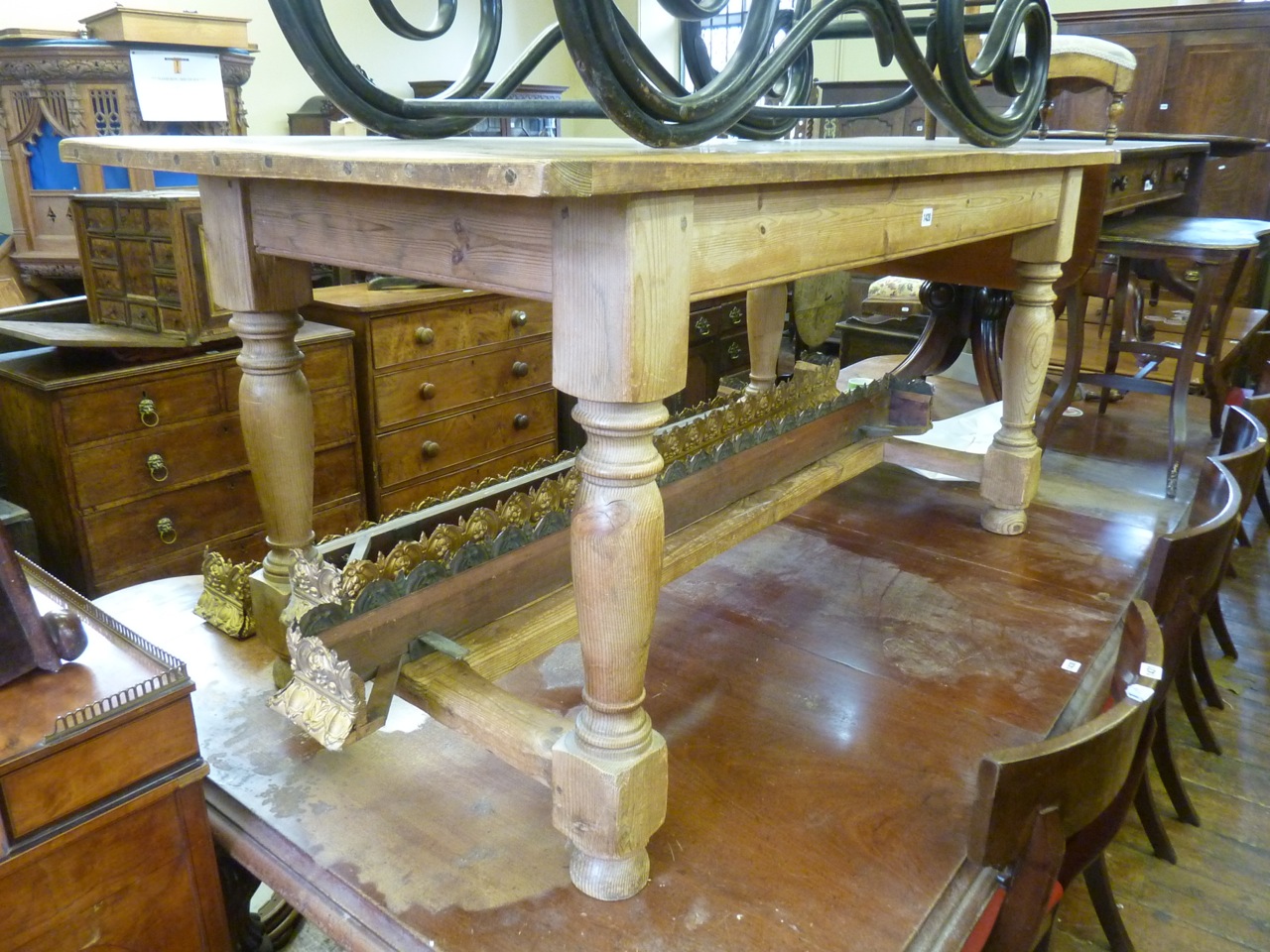 An old English style pine refectory table, the planked top with cleated ends raised on four turned