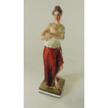 An early 19th century Staffordshire type figure of a young woman in classical style draperies and