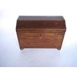 A Regency tea caddy with canted arched lid in mixed veneers with banded borders, inlaid escutcheon