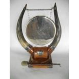A good quality 19th century table gong, flanked by a pair of polished cattle horns set within a