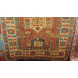 An old Eastern wool rug, the red central field interspersed with multi coloured medallion and