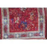 A red ground Kashmir carpet with a hunting scene, consisting of equestrian figures, tigers, other