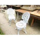 A pair of Victorian style cast aluminium garden chairs with anthemion backs, pierced circular