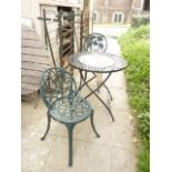 A contemporary painted steel terrace table with folding frame, the circular top with central faux